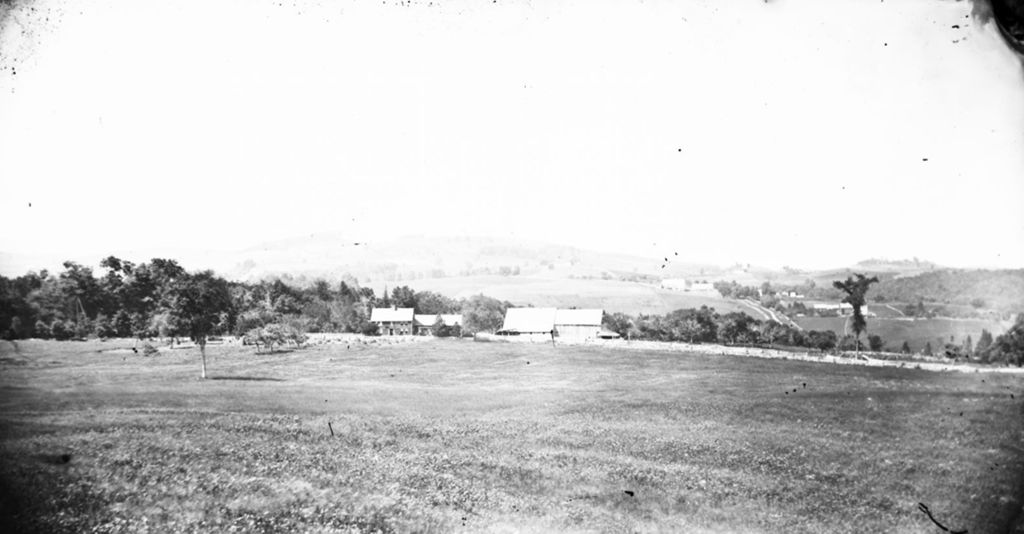 Miniature of House and barns across a field with rolling hills and fields in the background.