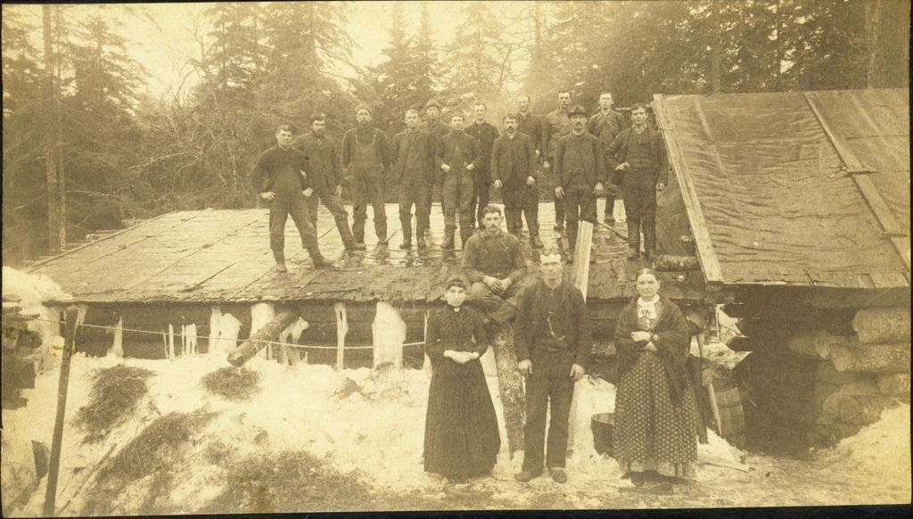 Miniature of Men and women standing on the roof and in front of a building