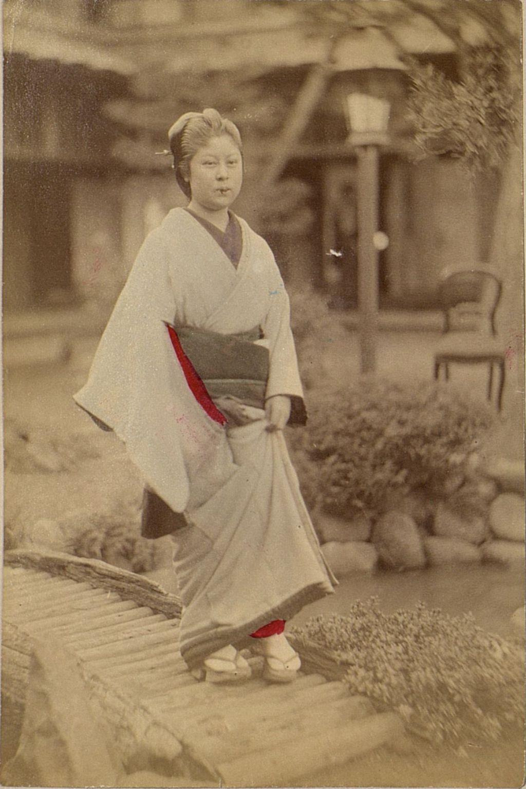 Miniature of Woman crossing bridge over pond